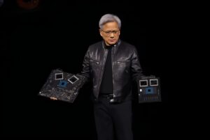 NVIDIA CEO presenting the NVIDIA Hopper H100 GPU at a tech event.