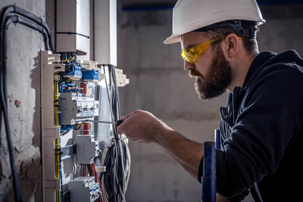 Ensuring Proper Installation and Longevity for Your Surge Protection Licensed electrician or technician safely installing or maintaining an electrical panel, emphasizing proper installation guidelines and the importance of professional care for electrical systems and surge protectors.